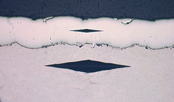 Hardness test micrographic image with diamond shaped impressions from testing equipment