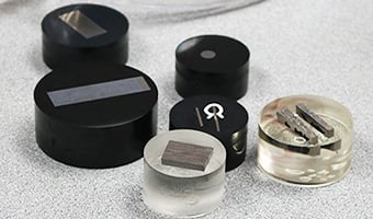 Metal samples of coated materials prepared for metallurgical examination in plastic-encapsulated discs
