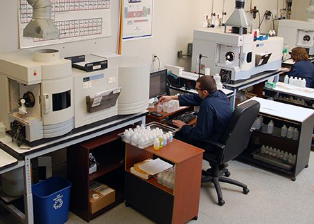 Overview of chemical analysis lab with technician performing ICP-MS