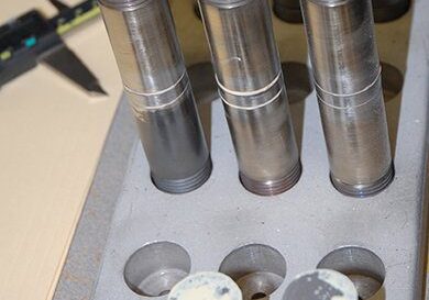 Bonded metal rods in sample holder showing several samples prepared for testing, and 2 samples that have been pulled apart