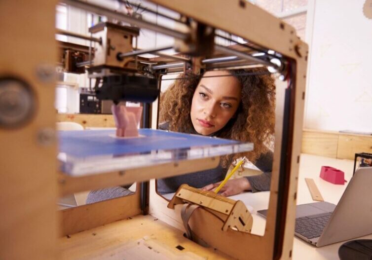 Technician observing 3D printing of AM component